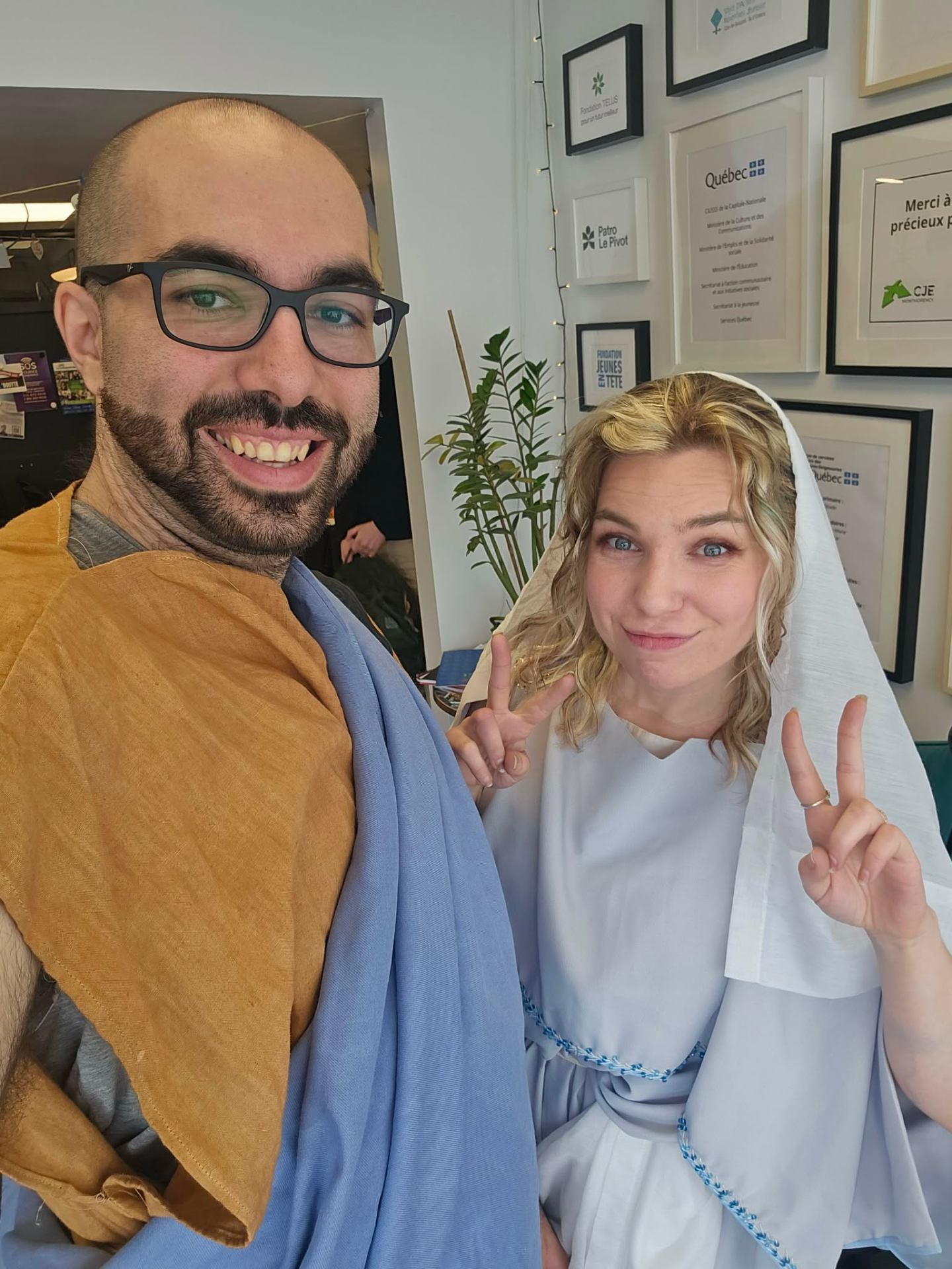 Deux personnes en costumes médiévaux souriant à la caméra