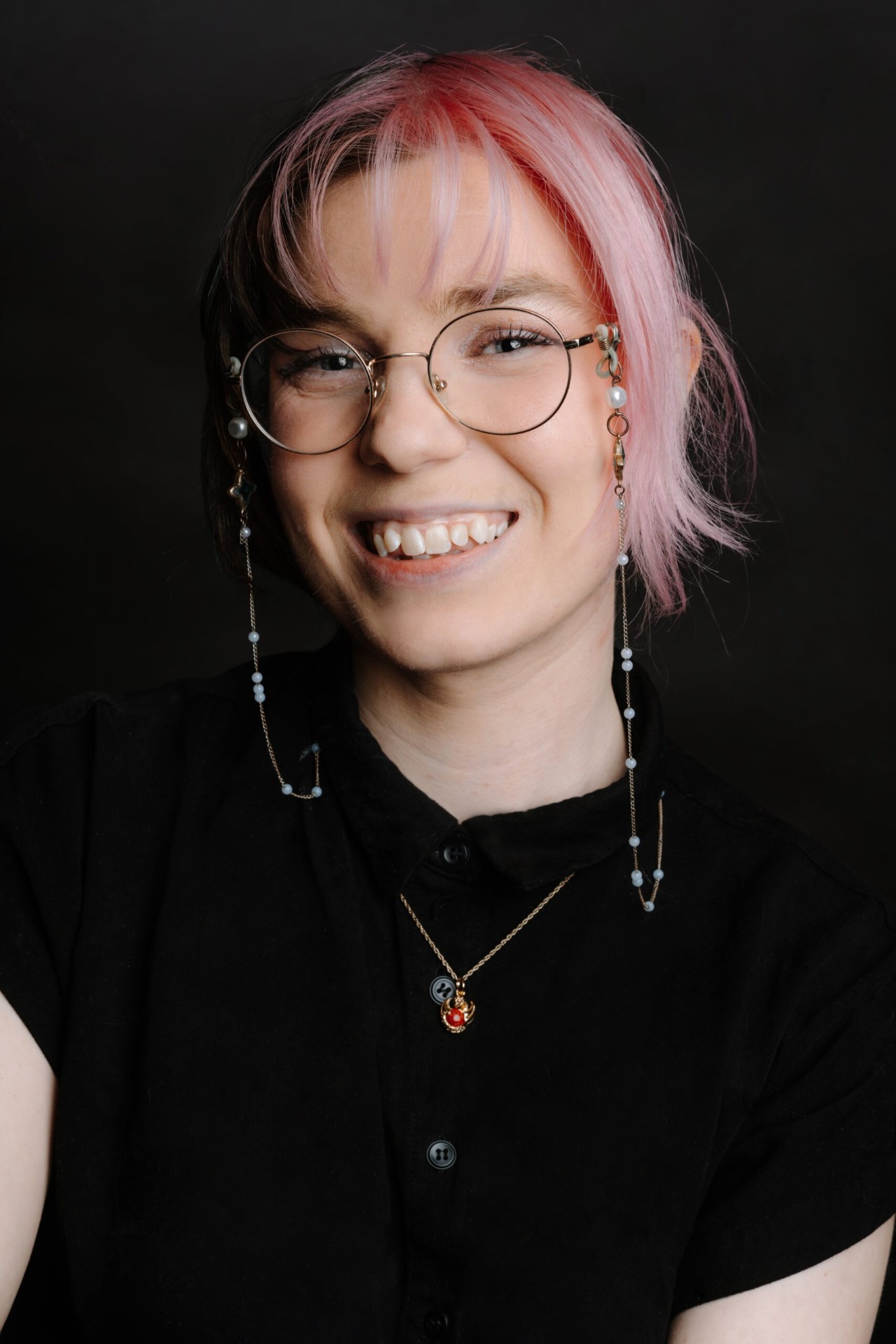 Sophie Blanchette — une jeune femme souriante avec des lunettes et des cheveux partiellement roses