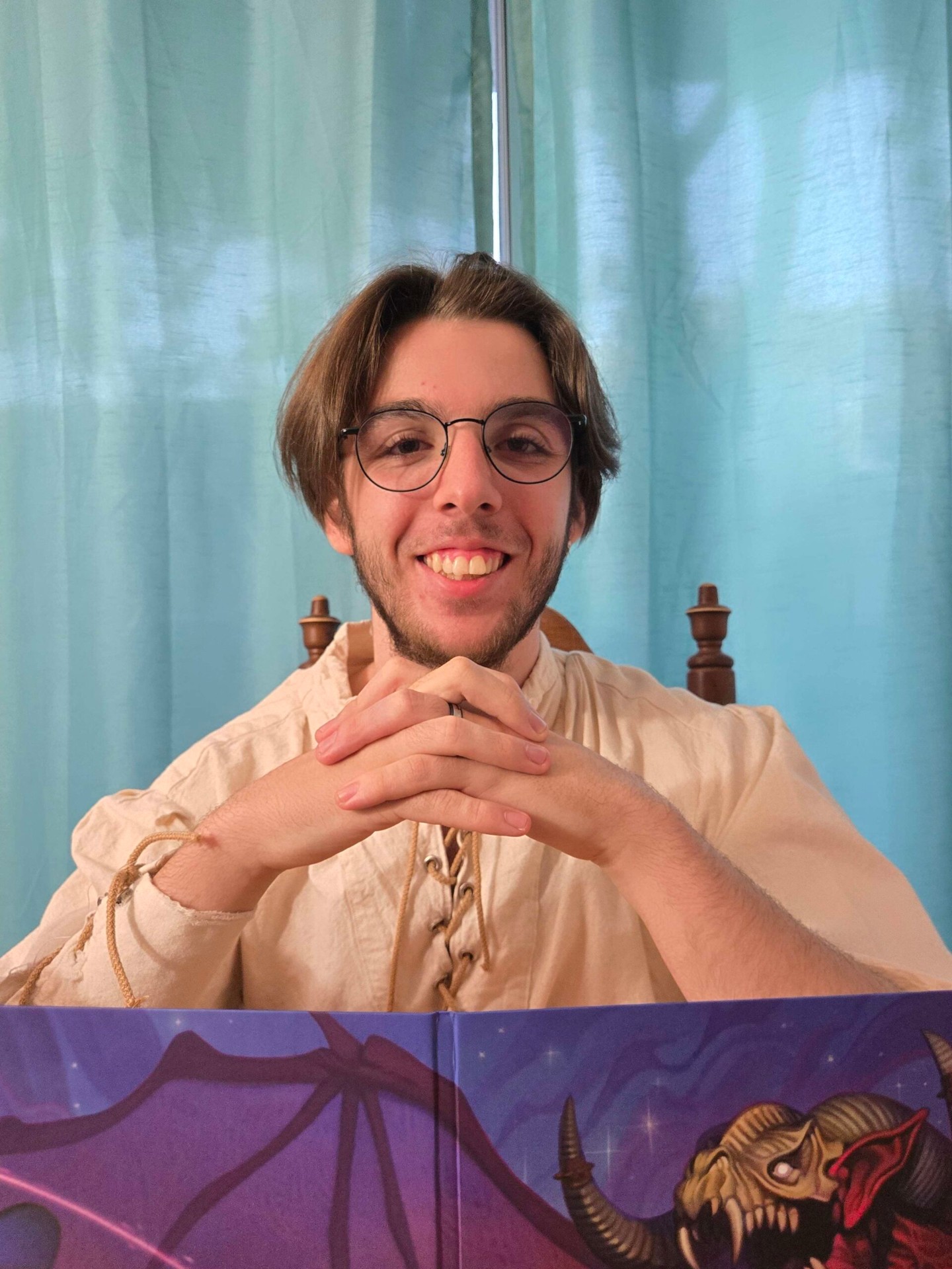 Jazon Tremblay — un jeune homme souriant avec des lunettes et une chemise médiévale devant un écran de maître du jeu