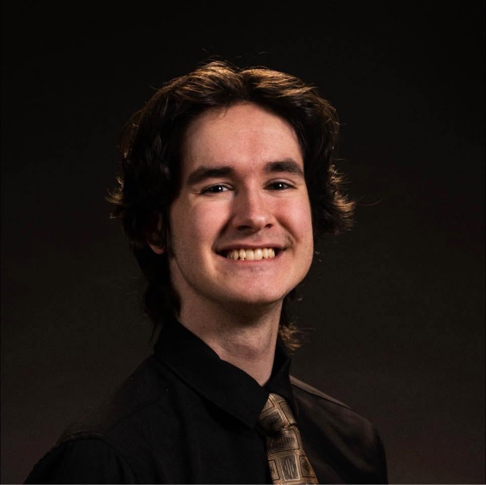 Mathias Côté — un jeune homme souriant avec une cravate sur fond noir