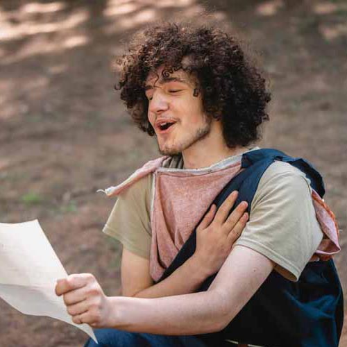 Pierre Cassidy-Fecteau — un jeune homme aux cheveux bouclés chantant ou déclamant un texte en forêt